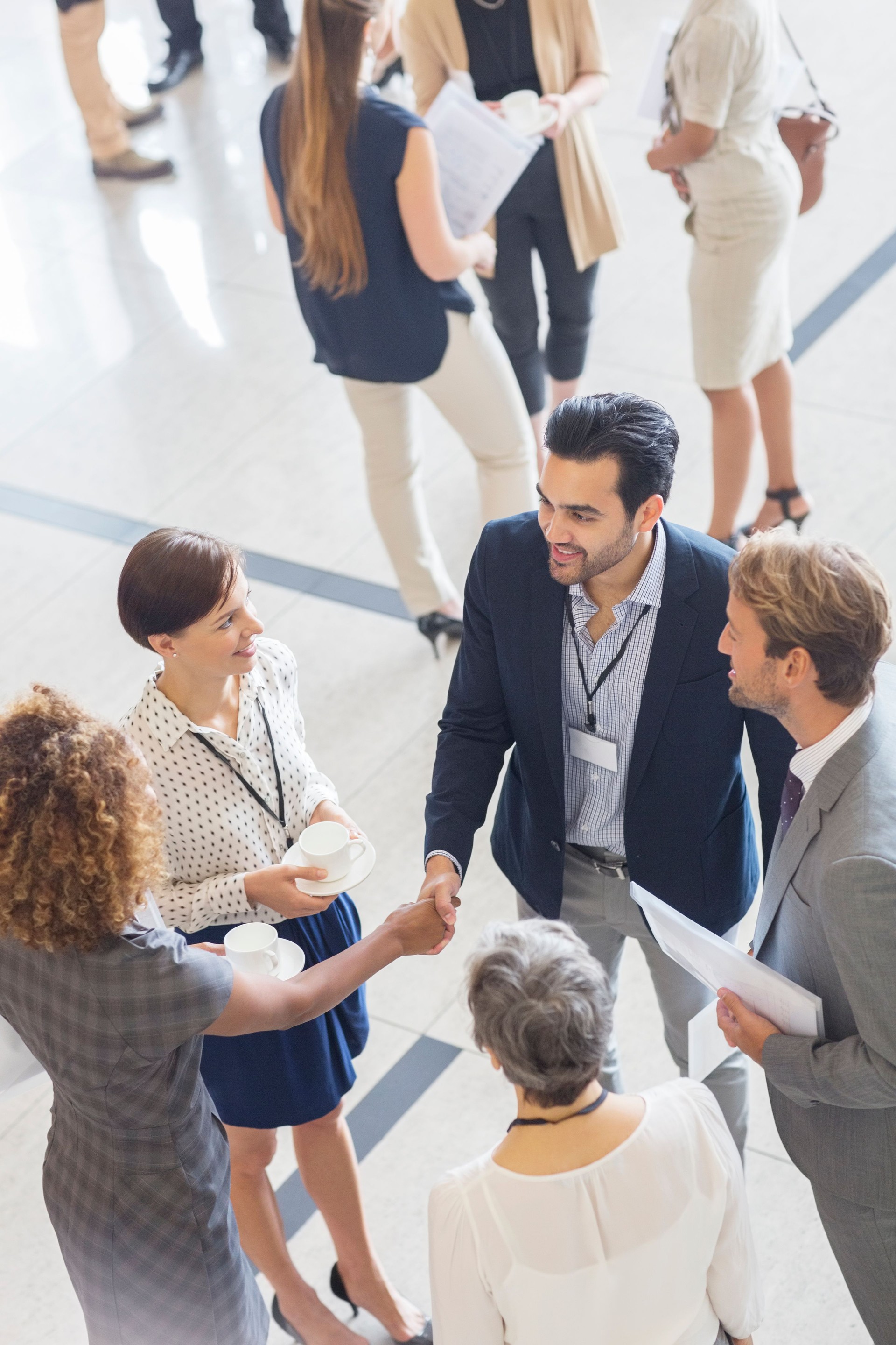 High angle view of group of business people shaking hands in office
